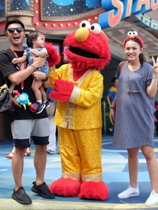 Disalah satu potret kebahagiaan liburan keluarga Ricky Harun, sang buah hati Kiya nampak lucu nan menggemaskan ketika berfoto bersama karakter Elmo.  (via instagram@rickyharun/Bintang.com)