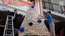 Karyawan membuat pohon Natal dari susunan donat di lobby hotel Dafam Semarang, Rabu (12/12). Pohon Natal setinggi 3 meter untuk menyambut Natal tersebut terdapat 2000 buah kue donat. (Liputan6.com/Gholib)
