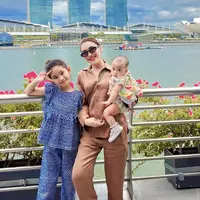 Ayu Ting Ting mengajak Bilqis dan keluarganya berlibur ke Singapura. Ayu tampil dengan one set coklat dari kemeja panjang hingga celana panjangnya. @ayutingting92