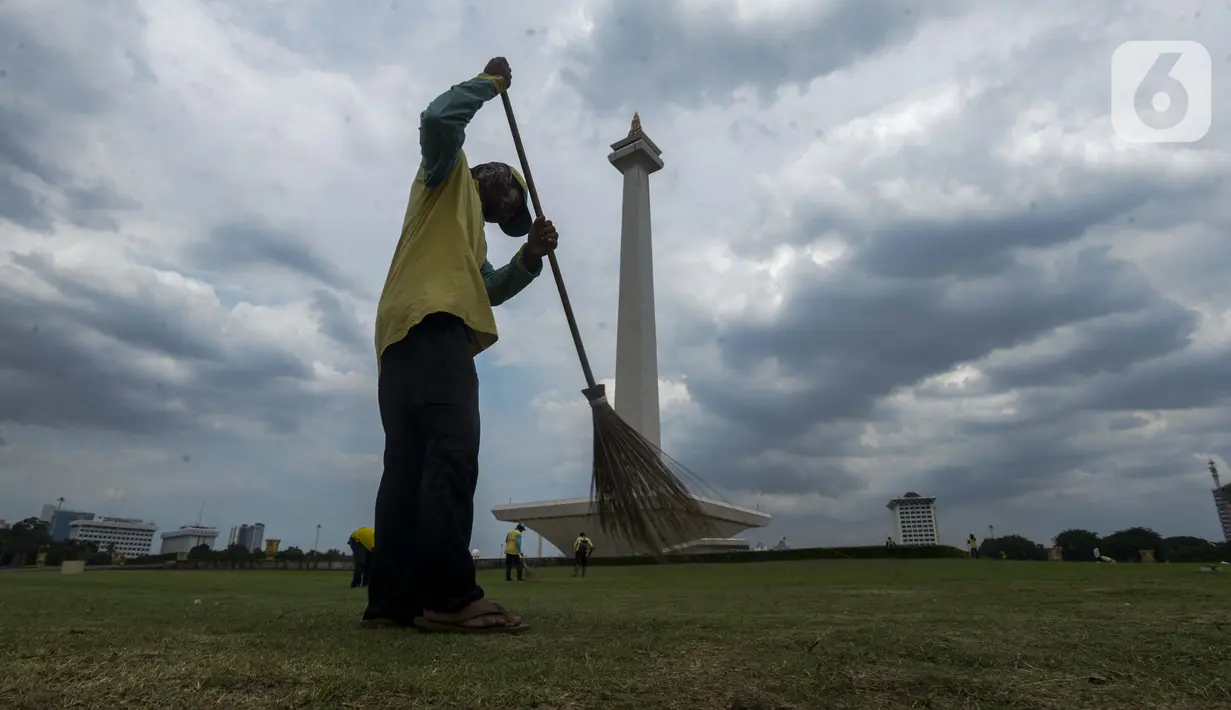 Petugas membersihkan rumput di kawasan Monumen Nasional (Monas) yang akan dijadikan arena lintasan balapan Formula E 2020, Jakarta, Selasa (11/2/2020). Pemerintah Provinsi DKI Jakarta akan menggelar ajang bertaraf internasional Formula E di kawasan Monas, Jakarta Pusat. (merdeka.com/Imam Buhori)