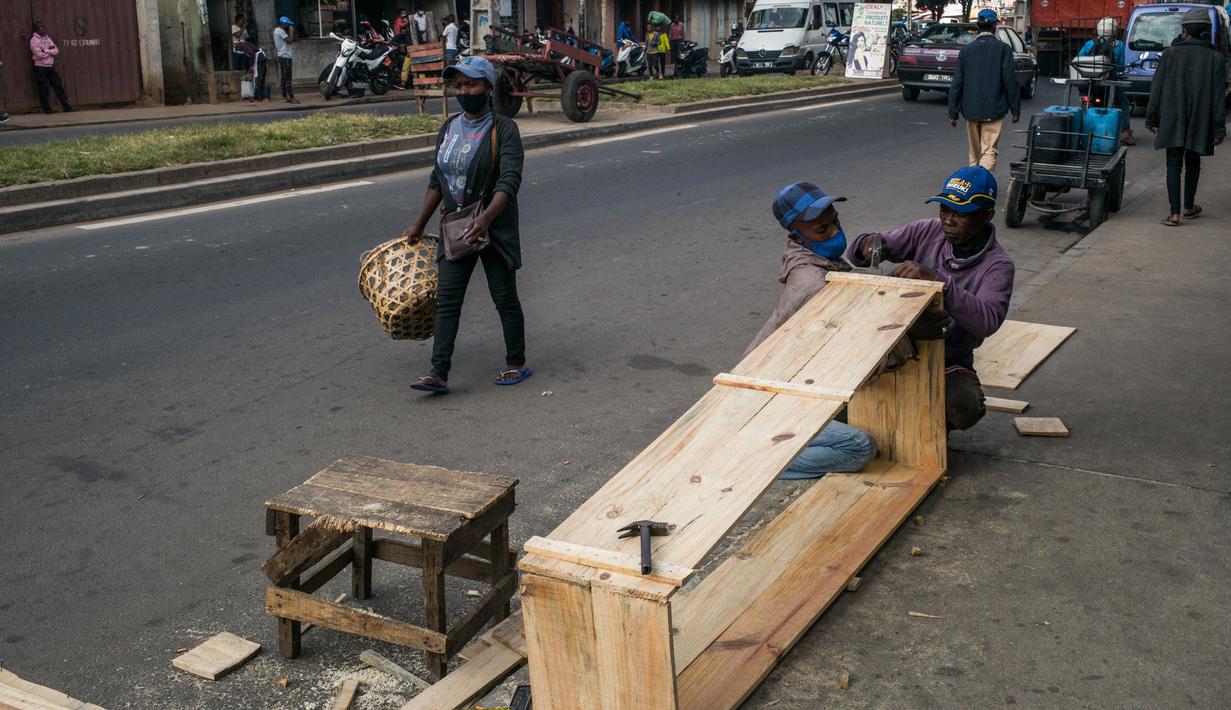 Mr. Jean dan timnya membuat peti mati murah di jalan, padahal kegiatan ini dilarang di jalan raya umum, di Antananarivo, Madagaskar, Rabu (14/4/2021). Peti mati dari kayu pinus yang diproduksi selama satu jam tersebut dijual antara Rp 350ribu hingga Rp 820ribu. (RIJASOLO/AFP)