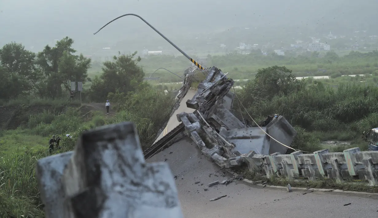 Wartawan berkumpul di samping jembatan Kaoliao yang runtuh di wilayah Hualien Taiwan timur (19/9/2022). Belum ada laporan korban jiwa akibat bencana alam tersebut. (AFP/Sam Yeh)