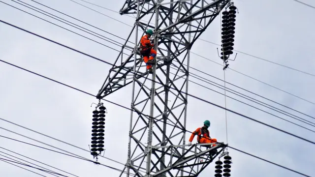 Petugas PLN memperbaiki Menara Sutet.