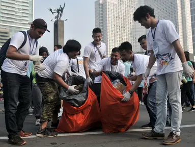 Relawan Gerakan Indonesia Bersih mengumpulkan sampah di area Car Free Day, Bundaran HI, Jakarta, Minggu (28/4/2019). Pemerintah meluncurkan aksi peduli sampah lewat 'Gerakan Indonesia Bersih' dengan sistem 3R (reduce, reuse, recycle) dalam menjaga lingkungan. (merdeka.com/Iqbal S. Nugroho)