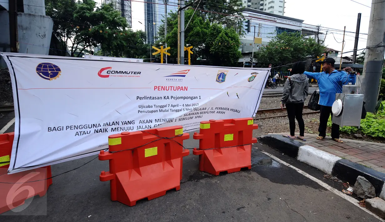 Warga berada di sekitar perlintasan KA Pejompongan 1 yang ditutup sementara, Jakarta, Rabu (12/4). Perlintasan KA Pejompongan 1 akan ditutup permanen pada 5 Mei mendatang. (Liputan6.com/Helmi Fithriansyah)