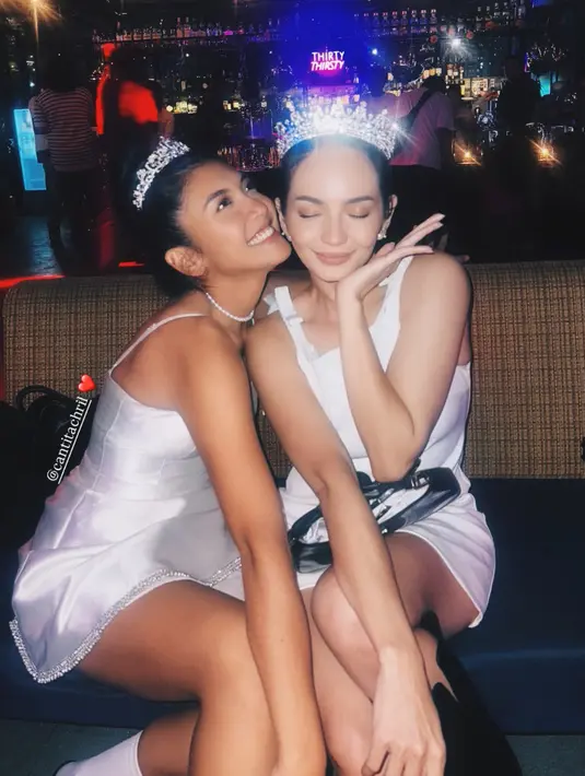 Canti juga mengenakan mini dress putih dengan model spaghetti strap. Ia juga mengenakan mahkota serta kalung mutiara chokernya. [@enzystoria]