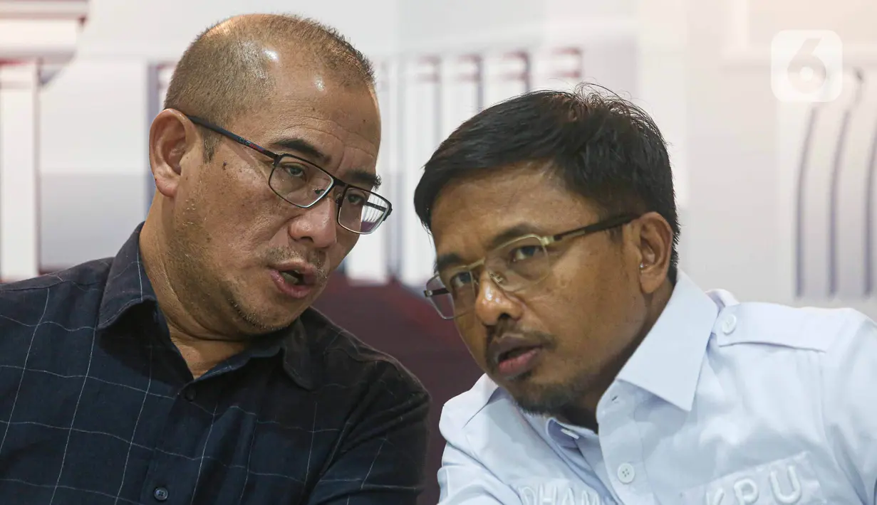 Ketua Komisi Pemilihan Umum (KPU) Republik Indonesia Hasyim Asy’ari (kiri) berbincang bersama anggota KPU RI Idham Holik disela-sela konferensi pers terkait pendaftaran pasangan calon presiden dan calon wakil presiden di Gedung KPU RI, Jakarta, Senin (16/10/2023). (Liputan6.com/Faizal Fanani)