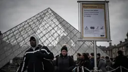 Pengunjung mengantre di luar Pyramid, pintu masuk utama menuju museum Louvre, di Paris, Rabu (4/3/2020). Louvre di Paris, museum yang paling banyak dikunjungi di dunia, kembali dibuka setelah pegawai yang khawatir dengan penularan virus corona setuju kembali masuk kerja. (Philippe LOPEZ/AFP)