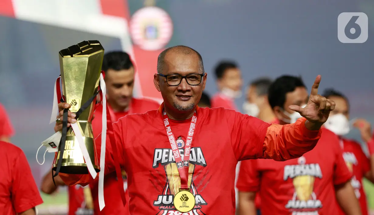Pelatih Persija Jakarta, Sudirman, mengangkat trofi usai menjuarai Piala Menpora 2021 di Stadion Manahan, Solo, Minggu (25/4/2021). (Bola.com/M Iqbal Ichsan)