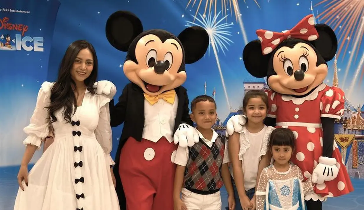 Rachel Vennya yang mengenakan dress putih berpita hitam mengajak kedua anaknya bertemu Minnie dan Mickey. Chava bahkan tampil mengenakan gaun biru putih seperti karakter Elsa Frozen. [@rachelvennya]