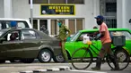 Petugas keamanan terlihat di luar Western Union sebelum penutup kantor di Havana, Kuba, Senin (23/11/2020). Layanan transfer uang terkemuka di dunia itu menutup lebih dari 400 gerainya di Kuba menyusul sanksi ekonomi terbaru yang dikeluarkan Amerika Serikat (AS) terhadap negara itu. (Yamil LAGE/AFP)