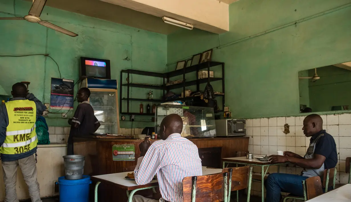 Pengunjung menonton televisi sebuah konferensi pers dari Pejabat Uni Afrika di sebuah restoran sambil menunggu hasil resmi pemilihan umum Kenya di Kisumu (10/8). Berdasar laporan, Uhuru Kenyatta masih unggul dari Raila Odinga. (AFP Photo/Jennifer Huxta)