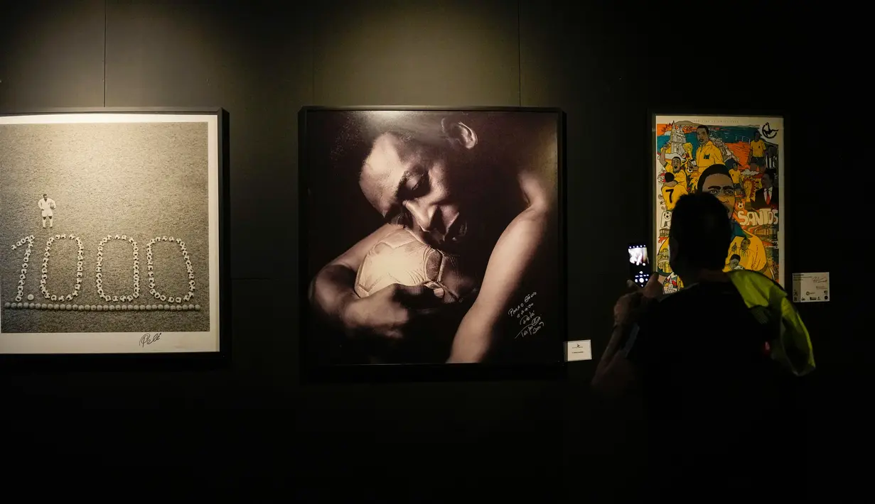 Seorang pengunjung mengambil foto di Museum Pele, Santos, Brasil, 26 Desember 2022. Di museum ini terdapat trofi, kaus, dan foto-foto Pele bersama para pemimpin dunia serta selebritis. (AP Photo/Matias Delacroix)