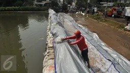 Warga saat membantu membetulkan tanggul di kawasan Perumahan Pantai Mutiara, Jakarta, Sabtu (4/6). Tingginya pasang air laut menyebabkan tanggul di Jalan Mutiara 1, Pluit, Penjaringan, sepanjang sekitar 50 meter jebol. (Liputan6.com/Gempur M Surya)