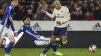 Striker Paris Saint Germain (PSG), Kylian Mbappe, terjatuh saat berebut bola dengan pemain RC Strasbourg, Kenny Lala, pada laga Liga 1 Prancis di Stadion Stade de la Meinau, Rabu (5/12). Kedua tim bermain imbang 1-1. (AP/Jean-Francois Badias)