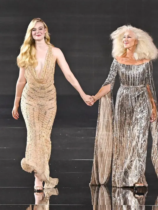 Helen Mirren tampil anggun dalam acara tersebut saat ia berjalan di runway bergandengan tangan dengan sesama duta L'Oréal Paris, aktris Elle Fanning. Aktris berusia 78 tahun itu mengenakan gaun off-the-shoulder berpayet perak. [@vanguardiaweb]