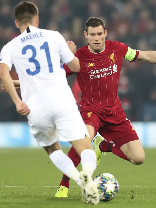 Gelandang Liverpool, James Milner berusaha merebut bola yang dibawa bek KRC Genk, Joakim Maehle pada pertandingan lanjutan Grup E Liga Champions di Stadion Anfield, Inggris (5/11/2019). Liverpool menang tipis 2-1 atas Genk. (AP Photo/Jon Super)