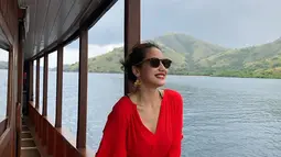 Saat liburan, Pevita tetap tampil modis dengan jumpsuit merah serta aksesoris kacamata hitam. Penampilannya ini banyak dipuji netizen. (Liputan6.com/IG/@pevpearce)