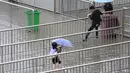 Sejumlah orang berjalan di atas pagar untuk mencoba menyebrang jalan yang terkena banjir, Shanghai, Tiongkok, Senin (24/8/2015). Banjir disebabkan oleh hujan deras yang menimpa kawasan tersebut. (Reuters/Aly Lagu)