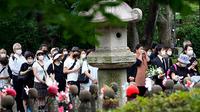 Orang-orang berbaris untuk mempersembahkan bunga dan doa untuk mantan Perdana Menteri Shinzo Abe, di Kuil Zojoji sebelum pemakamannya Selasa, 12 Juli, di Tokyo. (Eugene Hoshiko/AP)