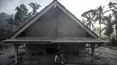 Seorang pria duduk di depan sebuah rumah yang terendam lumpur setelah letusan gunung berapi oleh Gunung Semeru di desa Kajar Kuning di Lumajang (5/12/2022). Gunung Semeru meletus pada tanggal 4 Desember memuntahkan awan abu panas setinggi satu mil dan sungai lava di sisinya sambil memicu evakuasi hampir 2.000 orang tepat satu tahun setelah letusan besar terakhirnya menewaskan puluhan orang. (AFP/Juni Kriswanto)