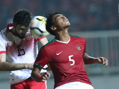 Gelandang Indonesia U-23, M Hargianto (kanan) berebut bola dengan pemain Bahrain, Hasan Alkarrani pada laga PSSI Anniversary 2018 di Stadion Pakansari, Kab Bogor, Jumat (27/4). Babak pertama Indonesia tertinggal 0-1. (Liputan6.com/Helmi Fithriansyah)