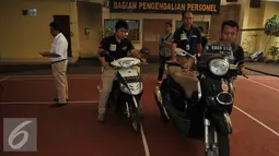 Petugas membawa motor hasil curian saat rilis kasus kejahatan di Jakarta, Senin (15/8). Kasus yang dirilis diantaranya tindak pidana perjudian dan pencucian uang dan tindak pencurian dengan kekerasan. (Liputan6.com/Gempur M Surya)