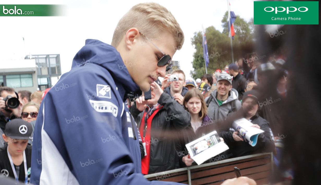Pebalap Sauber asal Swedia, Marcus Ericsson, melayani permintaan tanda tangan penggemarnya saat berada pada area fan zone jelang GP Australia di Sirkuit Albert Park, Melbourne, Sabtu (19/3/2016). (Bola.com/Yus Mei Sawitri)