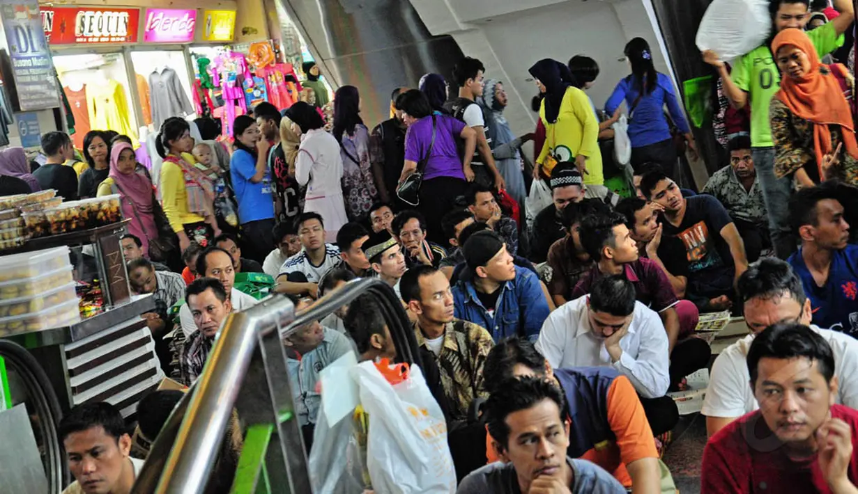 Tampak beberapa pengunjung wanita berlalu-lalang disekitar para jamaah melaksanakan salat Jumat di selasar Blok A Pasar Tanah Abang, Jakarta, Jumat (18/7/14). (Liputan6.com/Faizal Fanani)