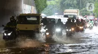 Sejumlah kendaraan melewati banjir yang merendam terowongan di Cawang, Jakarta, Jumat (19/2/2021). Hujan yang turun sejak semalam membuat sejumlah jalanan di Ibu Kota tergenang banjir dengan ketinggian sekitar 30-50 cm. (merdeka.com/Imam Buhori)
