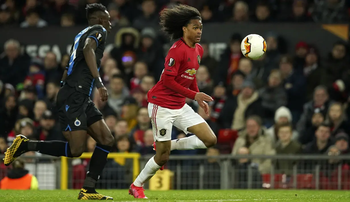 Penyerang Manchester United, Tahith Chong membawa bola dari kejaran pemain Club Brugge, Odilon Kossounou  pada pertandingan leg kedua babak 32 besar Liga Europa di Old Trafford, Inggris, Kamis, (27/2/2020). MU menang telak 5-0 atas Club Brugge. (AP Photo/Dave Thompson)