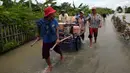 Warga berjalan melintasi banjir di Desa Sindangsari, Kabupaten Bekasi, Jawa Barat, Rabu (24/2/2021). Tim Tanggap Bencana Land Rover Club Indonesia (LRCI) melakukan drop logistik dan mengevakuasi warga yang sakit di Desa Sindangsari. (merdeka.com/Imam Buhori)