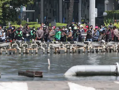 Warga berkumpul untuk menyaksikan parade pembalap MotoGP di kawasan Jakarta, Rabu (16/3/2022).  Gelaran parade MotoGP di Jakarta dalam rangka penyambutan event MotoGP Mandalika 2022. (Liputan6.com/Herman Zakharia)