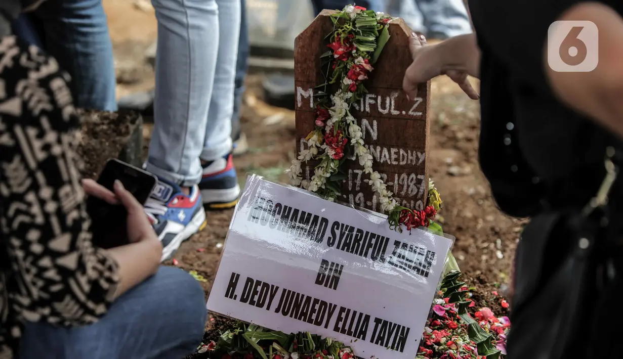 Bunga ditempatkan pada nisan mantan artis cilik Cecep Reza saat pemakaman di TPU Layur Penggilingan, Jakarta, Rabu (20/11/2019). Cecep Reza meninggal pada usia 31 tahun karena penyakit jantung. (Liputan6.com/Faizal Fanani)
