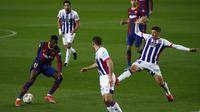 Penyerang Barcelona, Ousmane Dembele, berusaha melewati pemain Real Valladolid pada laga Liga Spanyol di Stadion Camp Nou, Selasa (6/4/2021). Barcelona menang dengan skor 1-0. (AP Photo/Joan Monfort)