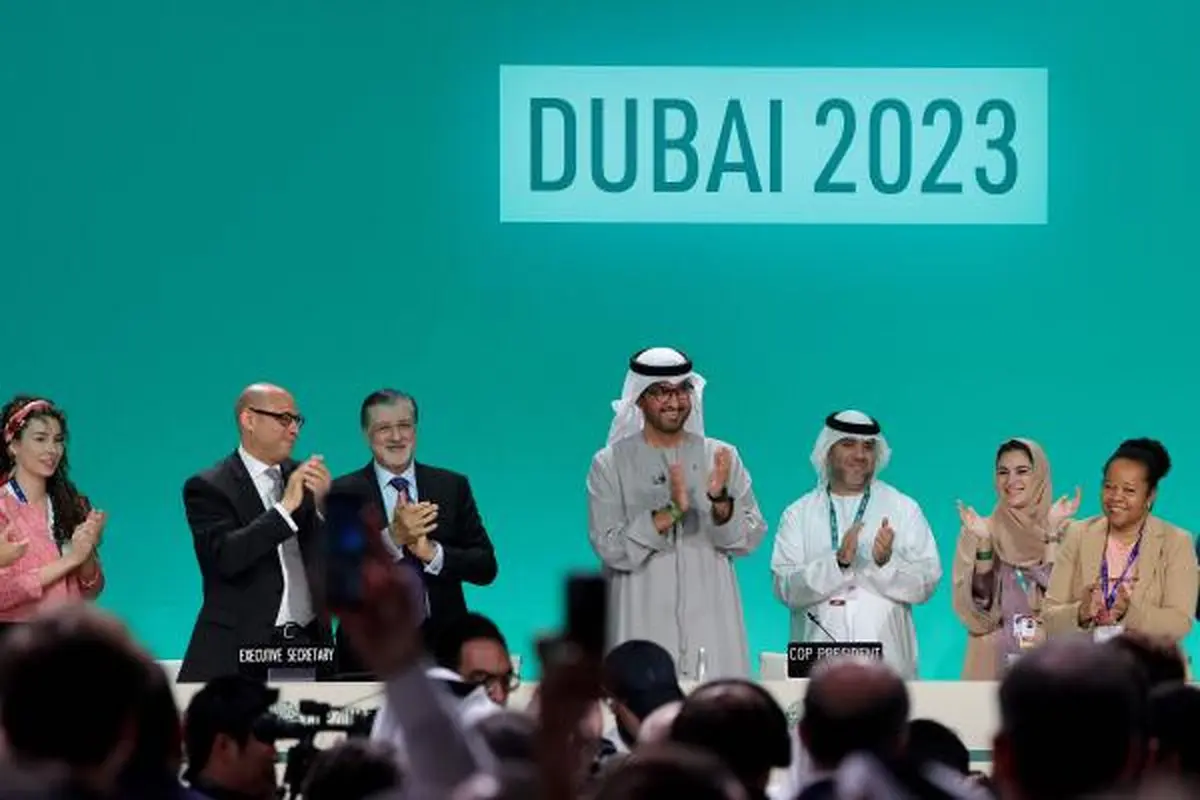 Presiden COP28 Sultan al-Jaber (tengah) bertepuk tangan di antara para pejabat lainnya pada 13 Desember 2023, di Dubai. (Giuseppe Cacace/ AFP)