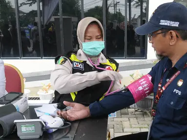 Petugas medis dari Rumah Sakit Polri melakukan pemeriksaan kesehatan kepada petugas-petugas Pemilu 2024 di GOR Kecamatan Duren Sawit, Jakarta, Jumat (16/2/2024). (merdeka.com/Imam Buhori)