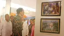 Presiden Jokowi melihat foto simpang susun semanggi hasil lomba foto pembangunan infrastruktur di Silang Monas, Jakarta, Minggu (27/8). Lomba ini bertemakan "Di Darat, Laut dan Udara lnfrastruktur Kita Bangun”. (Liputan6.com/Angga Yuniar)