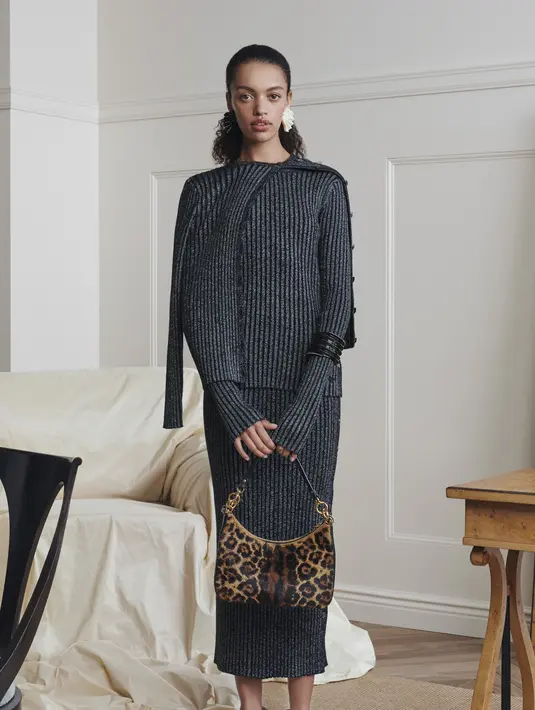 Set bahan rajut dari kardigan, blouse, sampai rok pensil maxi yang tampil menarik dengan tas motif leopard dan sepatu flat.  (Foto: Tory Burch Indonesia)