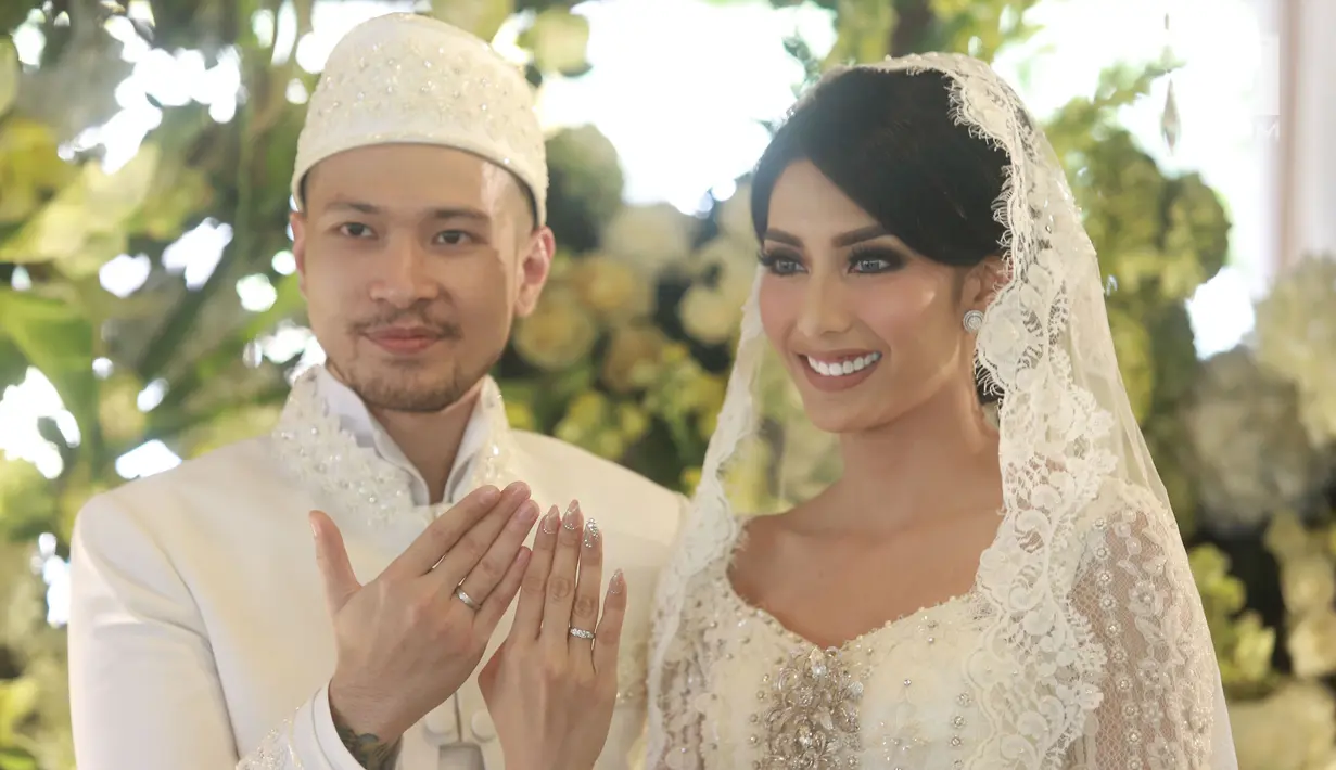 Aktris Tyas Mirasih dan suaminya Raiden Soedjono menunjukkan cincin pernikahan usai ijab kabul di kawasan Cilandak, Jakarta (8/7). Tyas Mirasih menikah dengan Raiden Soedjono dengan mas kawin perhiasan emas delapan gram. (Liputan6.com/Herman Zakharia)