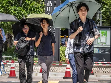 Orang-orang melindungi diri dari terik matahari dengan payung di Tokyo pada 27 Agustus 2025. (Yuichi YAMAZAKI/AFP)