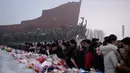 Penduduk Pyongyang meletakkan bunga di depan patung pemimpin Korea Utara Kim Il Sung dan Kim Jong Il selama Hari Peringatan Nasional di Bukit Mansu, Pyongyang (17/12).  Korea Utara tengah memperingati 7 tahun wafatnya  Kim Jong Il. (AFP Photo/Kim Won Jin)