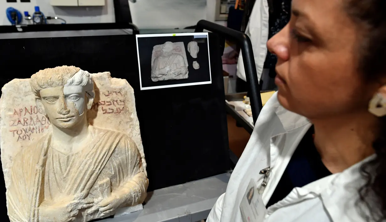 Peneliti melihat patung berumur sekitar 2-3 abad yang telah diperbaiki di Roma, Kamis (16/2). Dengan bantuan teknologi canggih, patung yang rusak tersebut bisa diperbaiki seperti sediakala. (AFP PHOTO / Alberto PIZZOLI)
