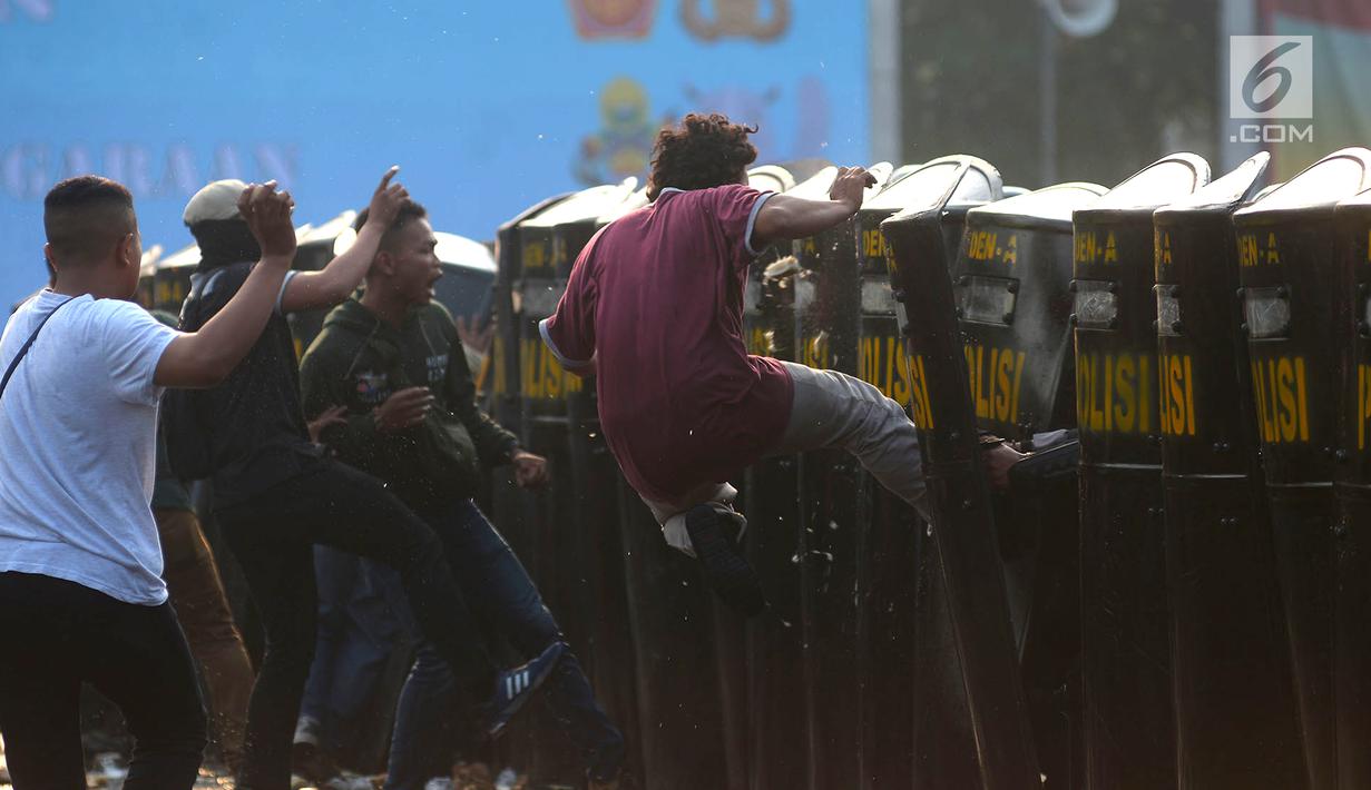 Petugas kepolisian menahan perusuh dalam apel pengamanan Asian Games 2018 di Lapangan Ditlantas Polda Metro Jaya, Jakarta, Selasa (31/7). Apel ini dilakukan untuk memastikan Ibu Kota kondusif selama Asian Games 2018. (Merdeka.com/Imam Buhori)