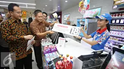 Direktur Marketing PT Indomarco Prismatama Wiwiek Yusuf dan Direktur Hubungan Eksternal PT HM Sampoerna Tbk. Yos Adiguna Ginting menyerahkan papan peraturan penjualan rokok di gerai Indomaret, Jakarta, Selasa (3/11). (Liputan6.com/Immanuel Antonius)