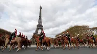 Pasukan berkuda Prancis membentuk formasi saat melintas di depan Menara Eiffel dalam parade kuda ke-20 di Paris, Prancis (19/11). Acara ini menjadi ajang untuk berkumpul bagi mereka pecinta kuda. (AFP Photo/Thomas Samson)