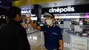 Petugas bioskop Gustavo Angel Oropeza Alvarez mengukur suhu seorang pria yang tiba di bioskop Cinepolis di Mexico City, Rabu (12/8/2020). Setelah ditutup hampir lima bulan akibat Corona, bioskop di ibu kota Meksiko dibuka kembali dengan kapasitas 30 persen. (AP Photo/Rebecca Blackwell)