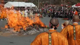 Biksu Buddha berdoa di depan kobaran api saat festival berjalan di atas api atau dikenal sebagai “Nagatoro Hi-Matsuri,” di kuil Fudoji, kota Nagatoro, Jepang, Minggu (5/3). Festival ini diadakan untuk menyambut datangnya musim semi. (Kazuhiro NOGI/AFP)