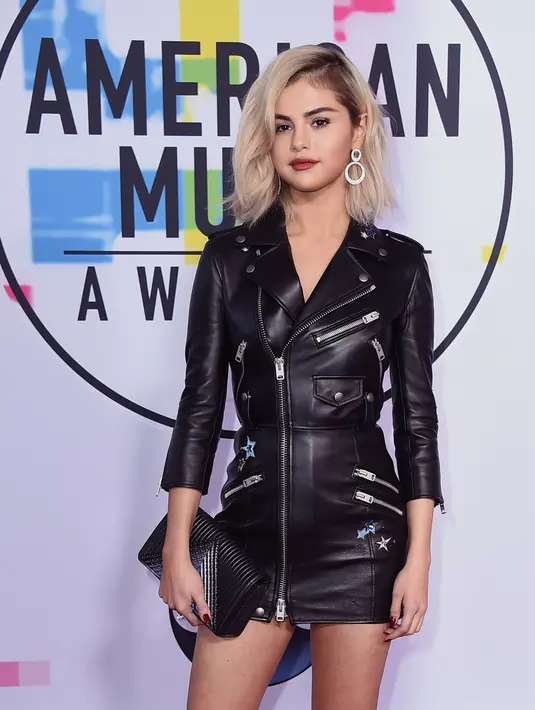 Penyanyi Selena Gomez menghadiri American Music Awards 2017 di Microsoft Theatre, Los Angeles, Minggu (19/11).  Melengkapi penampilannya, Selena memakai cincin dan anting Roberto Coin serta membawa clutch berbahan kulit. (Jordan Strauss/Invision/AP)