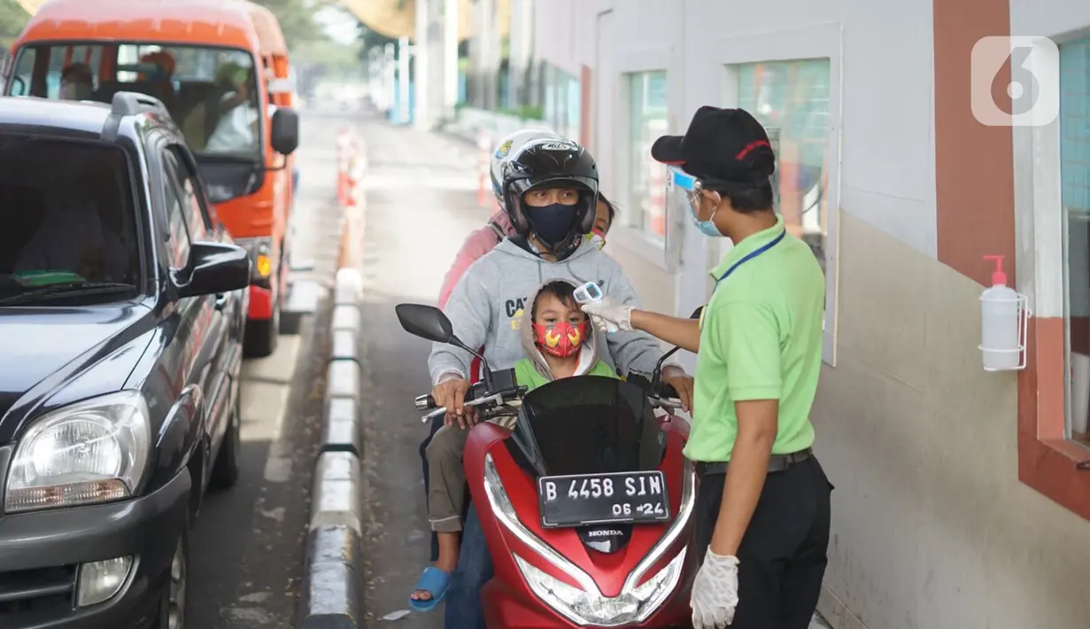 Petugas memeriksa suhu tubuh pengunjung di pintu masuk Taman Mini Indonesia Indah (TMII), Jakarta, Minggu (21/6/2020). Setelah tidak beroperasi akibat pandemic Covid-19, pengelola membuka kembali TMII dengan menerapkan protokol kesehatan dan pembatasan pengunjung. (Liputan6.com/Immanuel Antonius)